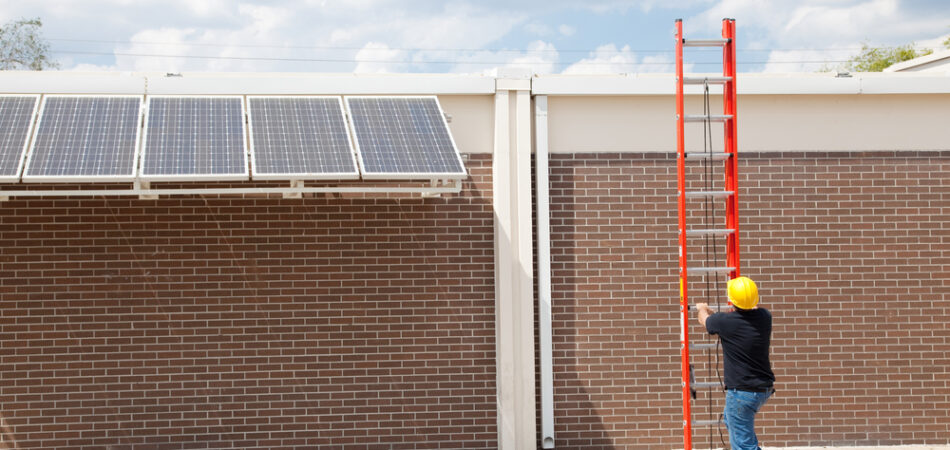 Wide,angle,view,of,a,construction,worker,preparing,to,climb
